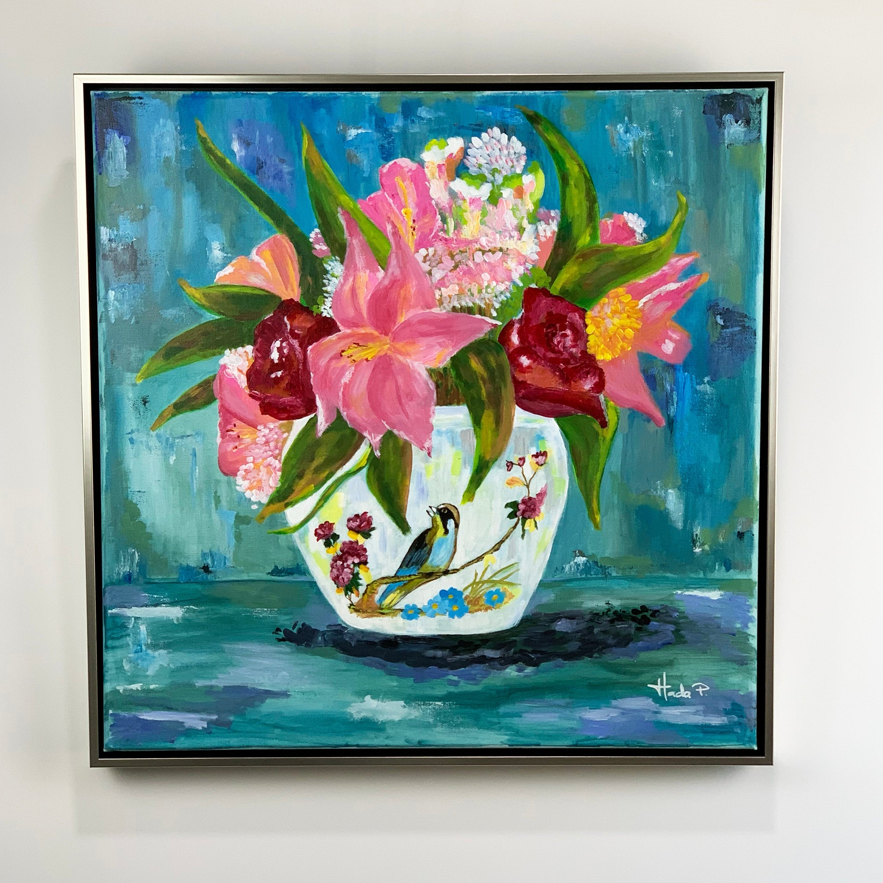Framed painting of a floral arrangement in a teacup on a white wall